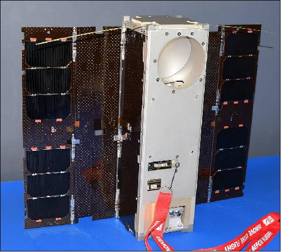 Figure 2: The MiRaTA nanosatellite is shown with the solar panels fully deployed. The spacecraft has a circular aperture at the top for the microwave radiometer antenna, used for atmospheric science measurements. There are also two small, thin tape-measure antennas on the top, used for UHF radio communication with the ground station (image credit: MIT/LL)