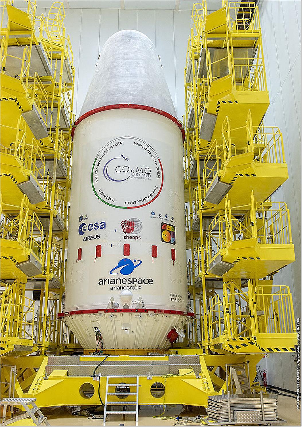 Figure 44: In this photo, the upper composite of the launcher and all passengers are encapsulated in the fairing and the composite is ready for integration with the 3-stage launcher. The fairing sticker features, among others, the ESA and Cheops mission logos and the winning design of the Cheops fairing sticker competition, on the left, created by Denis Vrenko (image credit: ESA/CNES/Arianespace/Optique vidéo du CSG/S Martin)