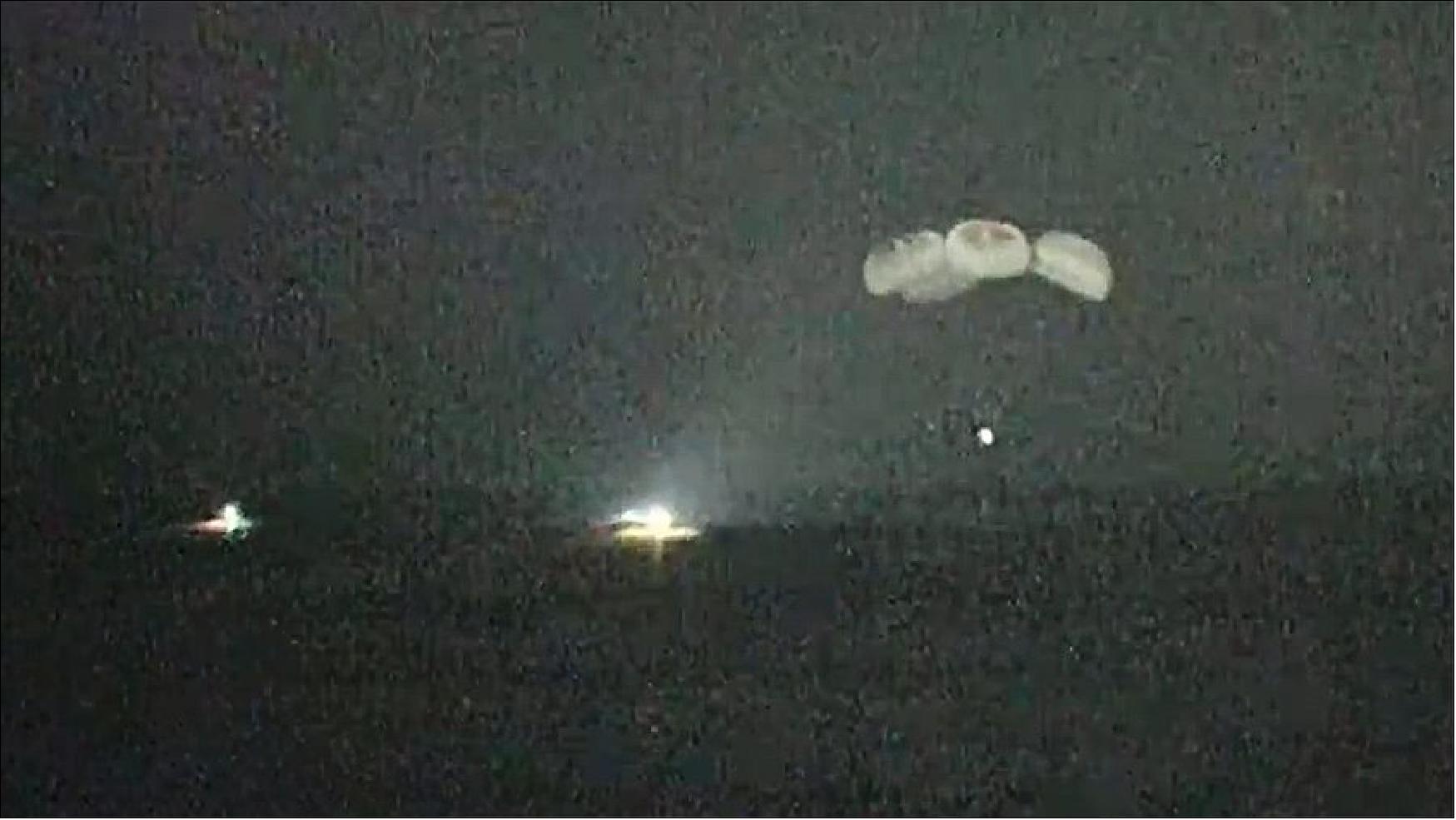 Figure 8: A night-vision camera captures the SpaceX Crew Dragon parachuting to splashdown in the Gulf of Mexico as fast boats arrive to retrieve the crew (image credit: NASA TV) 8)