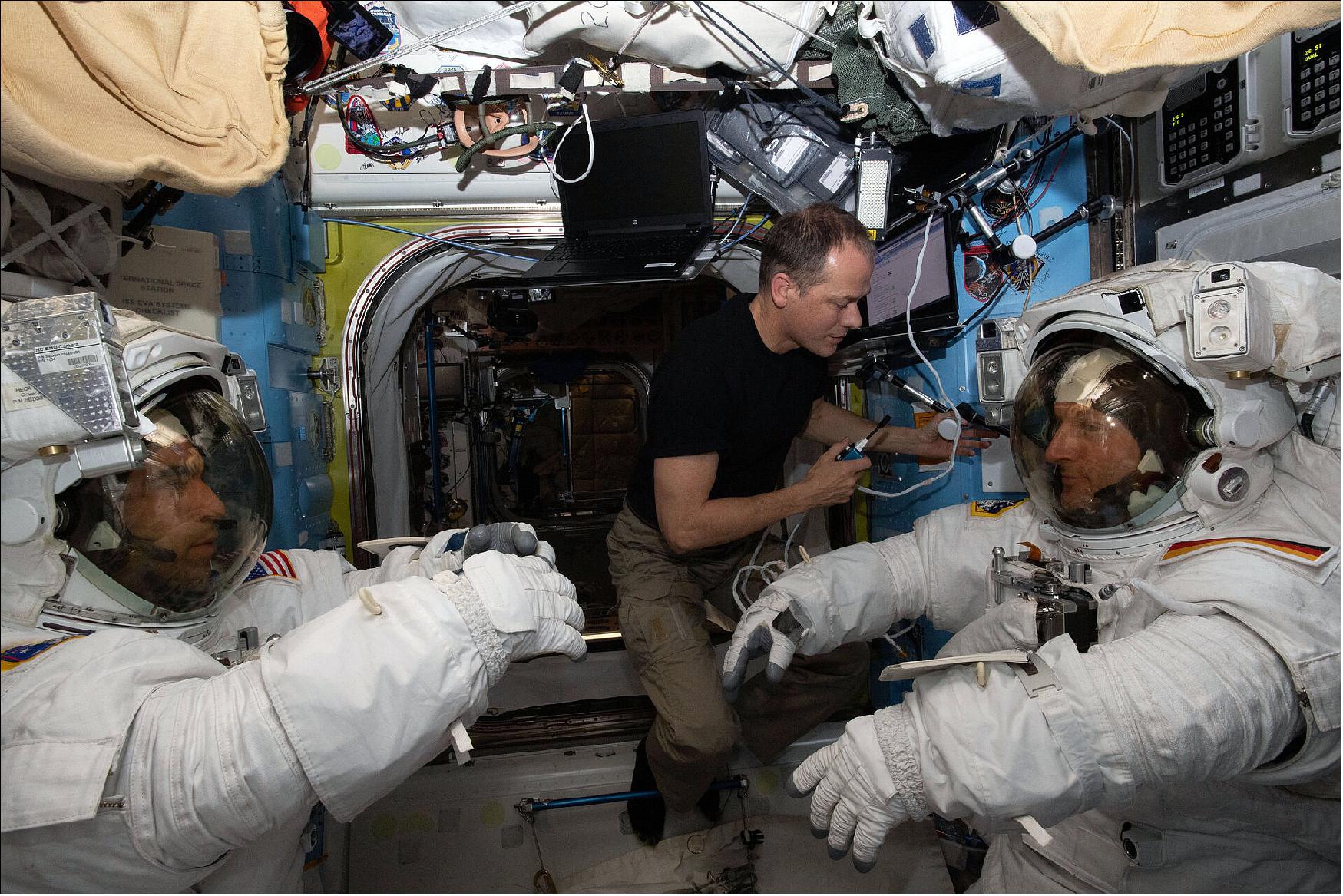 Figure 12: NASA astronaut Raja Chari (left) and ESA astronaut Matthias Maurer (right) check the fit of their Extravehicular Mobility Unit (EMU) spacesuits ahead of a spacewalk scheduled for 23 March 2022. The pair are helped by NASA astronaut Tom Marshburn (image credit: ESA/NASA)