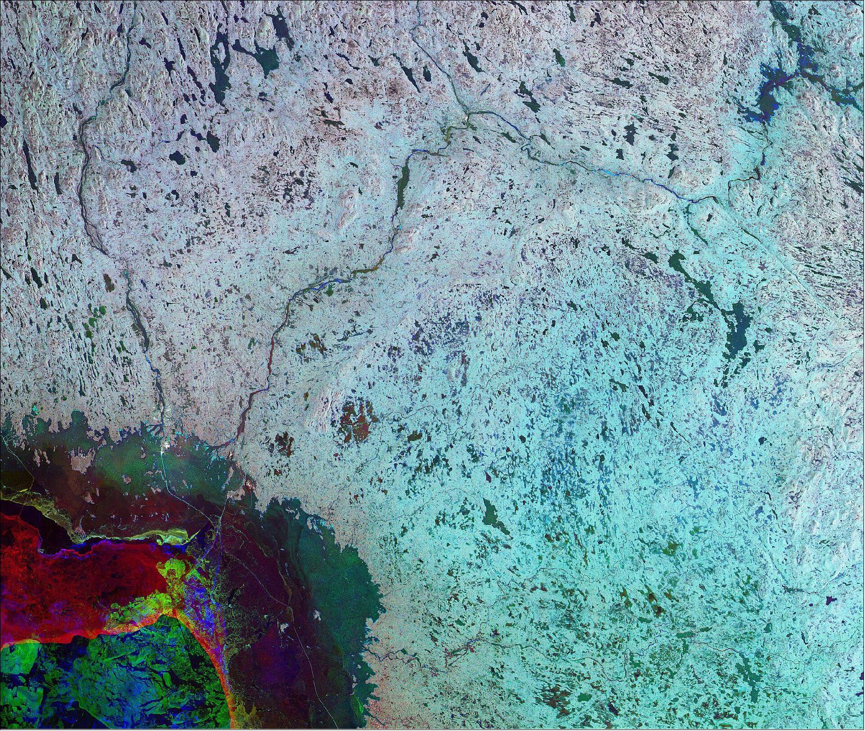 Figure 1: This image combines three radar acquisitions from the Copernicus Sentinel-1 mission to show changes in land conditions over time. The first image from 28 February 2019 is associated with green, the second from 11 March is linked to red, and the third from 04 April depicts changes in blue. The changes that took place over time in this image are largely seen in the bottom-left of the image, where sea ice in the Gulf of Bothnia has shifted substantially along the coast. The Gulf of Bothnia, the northernmost arm of the Baltic Sea, is situated between Finland’s west coast and Sweden’s east coast. As it receives the water of so many rivers, including the Torne and Kemijoki rivers visible in the image, its salinity is extremely low, and ice cover is maintained for up to five months during the winter. There are many small islands, making navigation in the gulf difficult. For this reason, vessels travelling in the gulf receive icebreaker assistance on their journey in the ice-covered waters, and follow the straight lines easing their navigation. Straight lines can be seen coming from the Port of Röyttä and the Port of Ajos. This image is also featured on the Earth from Space video program (image credit: ESA, the image contains modified Copernicus Sentinel data (2019), processed by ESA, CC BY-SA 3.0 IGO)