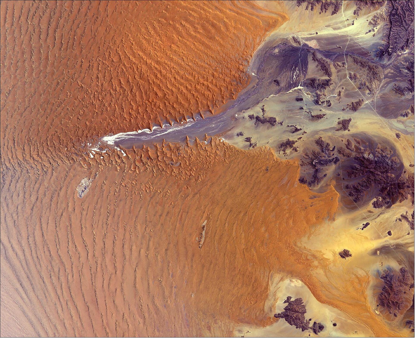 Figure 41: In this image, captured on 27 October 2019, a large portion of the Namib-Naukluft National Park is visible. The park covers an area of almost 50,000 km2 and encompasses part of the Namib Desert and the Naukluft Mountains to the east. Straight, white lines visible in the right of the image are roads that connect the Namib-Naukluft National Park with other parts of Namibia. This image is featured on the Earth from Space video program (image credit: ESA, the image contains modified Copernicus Sentinel data (2019), processed by ESA, CC BY-SA 3.0 IGO)