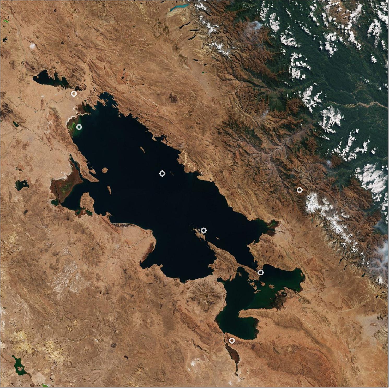 Figure 76: Forty-one islands rise from Titicaca’s waters, the largest of which, Titicaca Island, or Isla del Sol in Spanish, can be seen just off the tip of the Copacabana Peninsula in Bolivia. Several green algal blooms can be seen in the lake, including in the lake’s northwest and southeast corners. Snow in the Andes mountain range can be seen in the top-right of the image. This image is also featured on the Earth from Space video program (image credit: ESA, the image contains modified Copernicus Sentinel data (2020), processed by ESA, CC BY-SA 3.0 IGO)