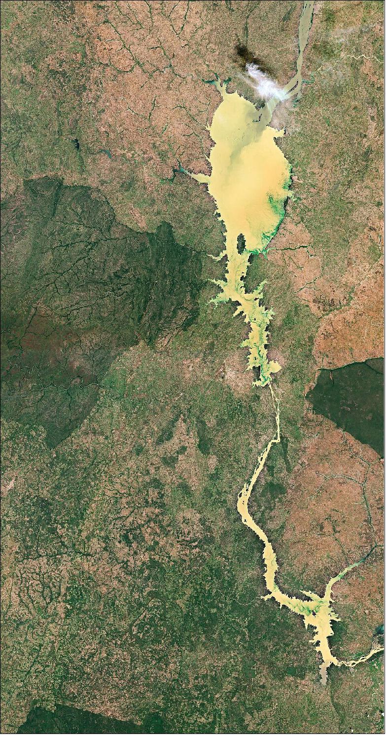 Figure 4: Kainji Lake was created in 1968 by the construction of the Kainji Dam and covers an area of around 1300 km2 with a mean depth of 12 m. Water from the Niger River, the third-longest river in Africa, enters the lake in the north. The grey-colored waters here mix with the striking, yellow-colored waters of Kainji Lake, creating a distinct sediment plume moving southwards. The emerald-green streaks are vegetation and algae floating on the surface of the lake. This image, captured on 11 November 2020, is also featured on the Earth from Space video program (image credit: ESA)