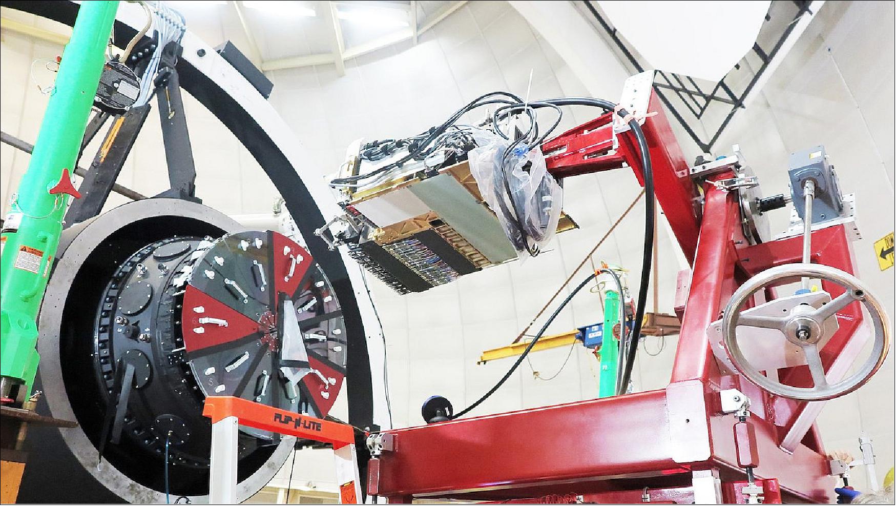 Figure 13: A machine positions a focal plane "petal" in preparation for its installation. Ten wedge-shaped petals make up DESI's focal plane (image credit: DESI Collaboration)