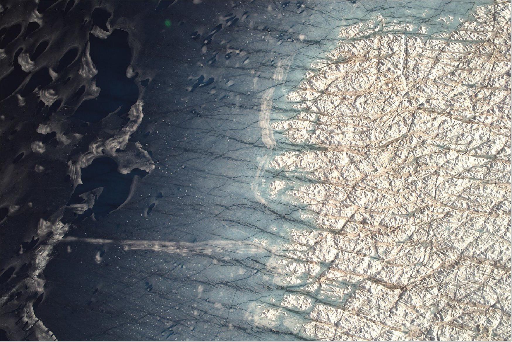 Figure 3: The shores of a refreezing lake on the surface of Zachariæ Isstrøm in northeast Greenland (image credit: NASA, Jeremy Harbeck)