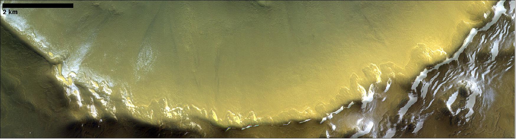 Figure 56: In this image, taken by the CaSSIS camera onboard ESA’s ExoMars Trace Gas Orbiter, the south-eastern wall of a 35 km-wide crater is seen. The image captures its permanent deposits of water ice, which survive the summer months due to the low average sunlight at high latitudes. The image is centered at 192.99ºE/70.4ºN. It was taken on 29 October 2019 (image credit: ESA/Roscosmos/CaSSIS, CC BY-SA 3.0 IGO)