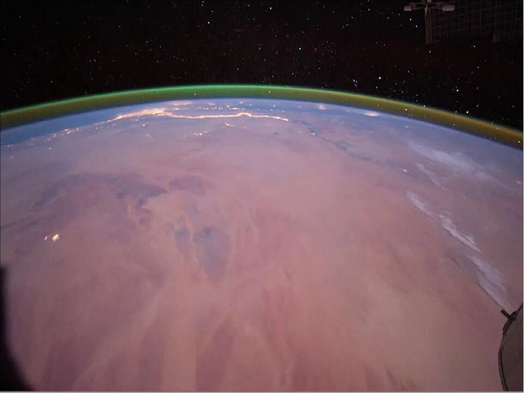 Figure 51: Airglow observed from the ISS. Airglow occurs in Earth's atmospheres as sunlight interacts with atoms and molecules within the atmosphere. In this image, taken by astronauts aboard the International Space Station (ISS) in 2011, a green band of oxygen glow is visible over Earth's curve. On the surface, portions of northern Africa are visible, with evening lights shining along the Nile river and its delta (image credit: NASA) .