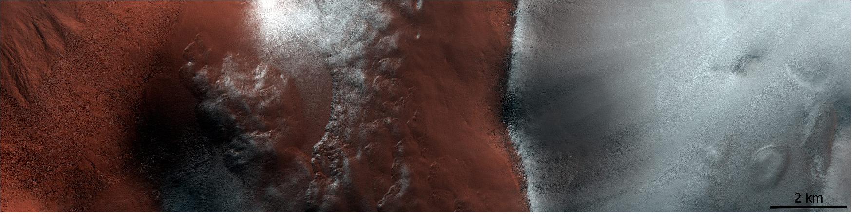 Figure 43: Argyre impact basin after spring equinox. This image of the Argyre impact basin in the southern highlands of Mars was taken on 28 April 2020 just as Mars had passed its southern hemisphere spring equinox. The seasonal ice in the 800km-long impact basin is receding while the ridge on the right side of the image is still covered with frost. The image is centered at 57.5°S, 310.2°E. The frost-covered ridge is facing the pole, therefore receiving less solar radiation than the neighboring equator-facing slope. On Mars, incoming solar radiation transforms the ice into water vapor directly without melting it first into water in a process called sublimation. Since the north-facing slope (on the left) has had a longer exposure to solar radiation, its ice has sublimated more quickly (image credit: ESA/ExoMars/CaSSIS)