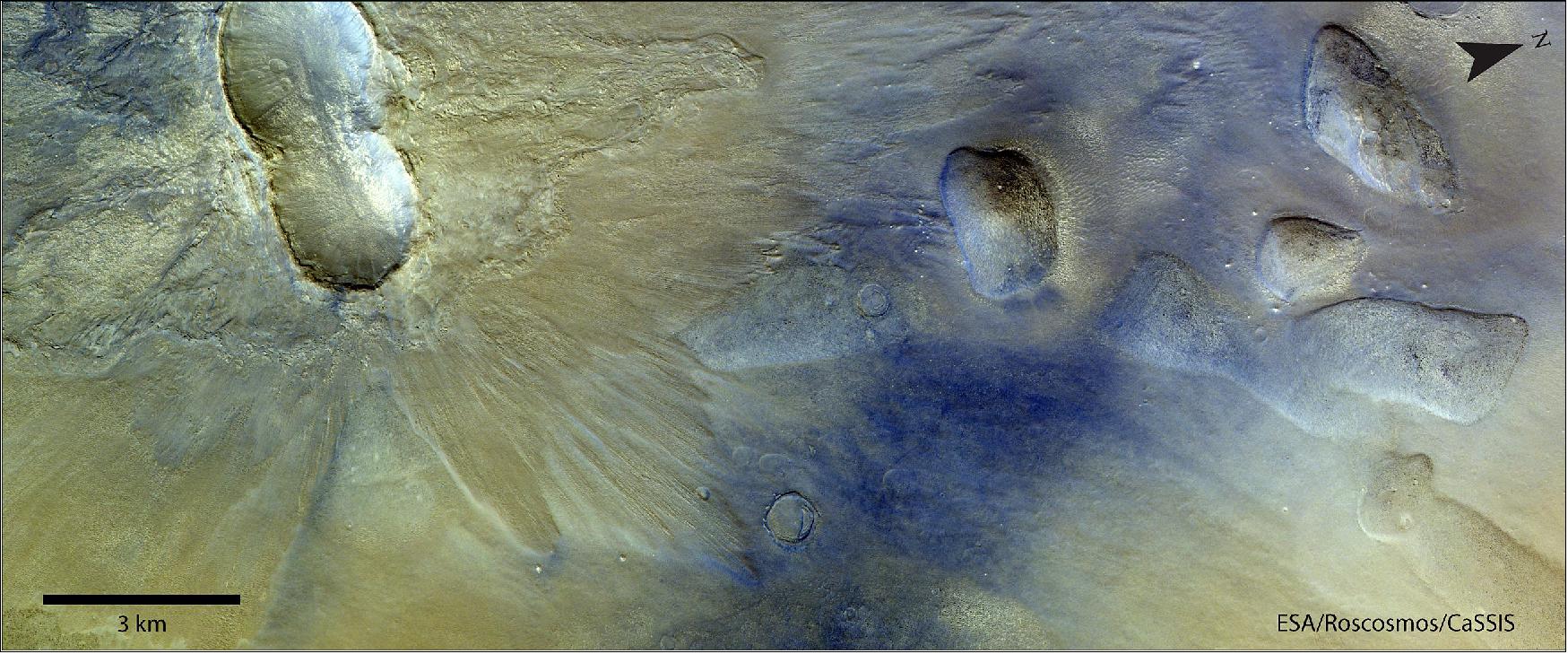 Figure 17: The crater duo is located in an otherwise smooth plain of Arcadia Planitia [39.1ºN/174.8ºE]. Double craters like these are formed when two meteorites impact the surface simultaneously and in very close proximity. The two impactors would have originated from the same object that broke apart when it entered the martian atmosphere. The two craters are of similar size, which means that the two projectiles were approximately the same size as well (image credit: ESA/Roscosmos/CaSSIS, CC BY-SA 3.0 IGO)