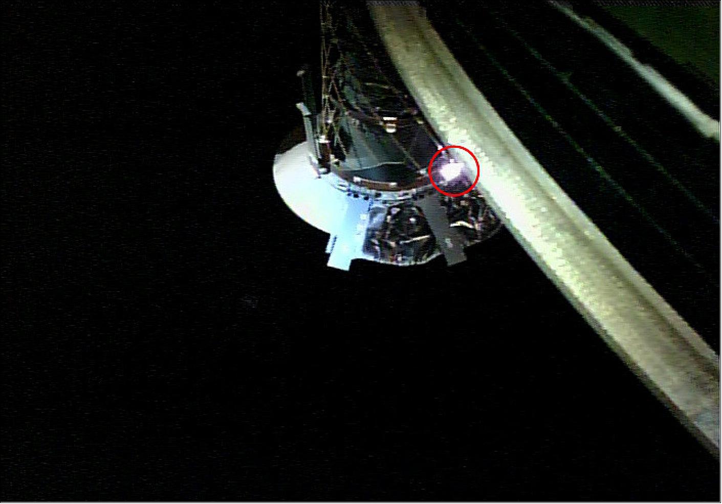 Figure 78: Test photograph of the sampler horn taken by the Small Monitor Camera (CAM-H) on April 16, 2018. The shiny part in the red circle is the target plate of the sampler horn which is integrated with the LRF-S2 laser. If the laser misses this plate, touchdown is in process and bullets will fire to stir up surface material (image credit: JAXA)