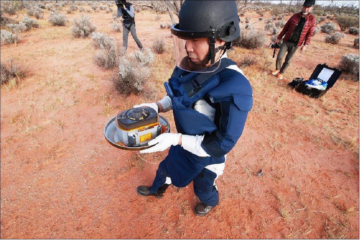 Figure 13: A JAXA scientist holds the capsule with samples collected from the distant asteroid Ryugu that were recovered in the South Australia desert after they were dropped off by Japanese space probe Hayabusa-2 (image credit: JAXA)