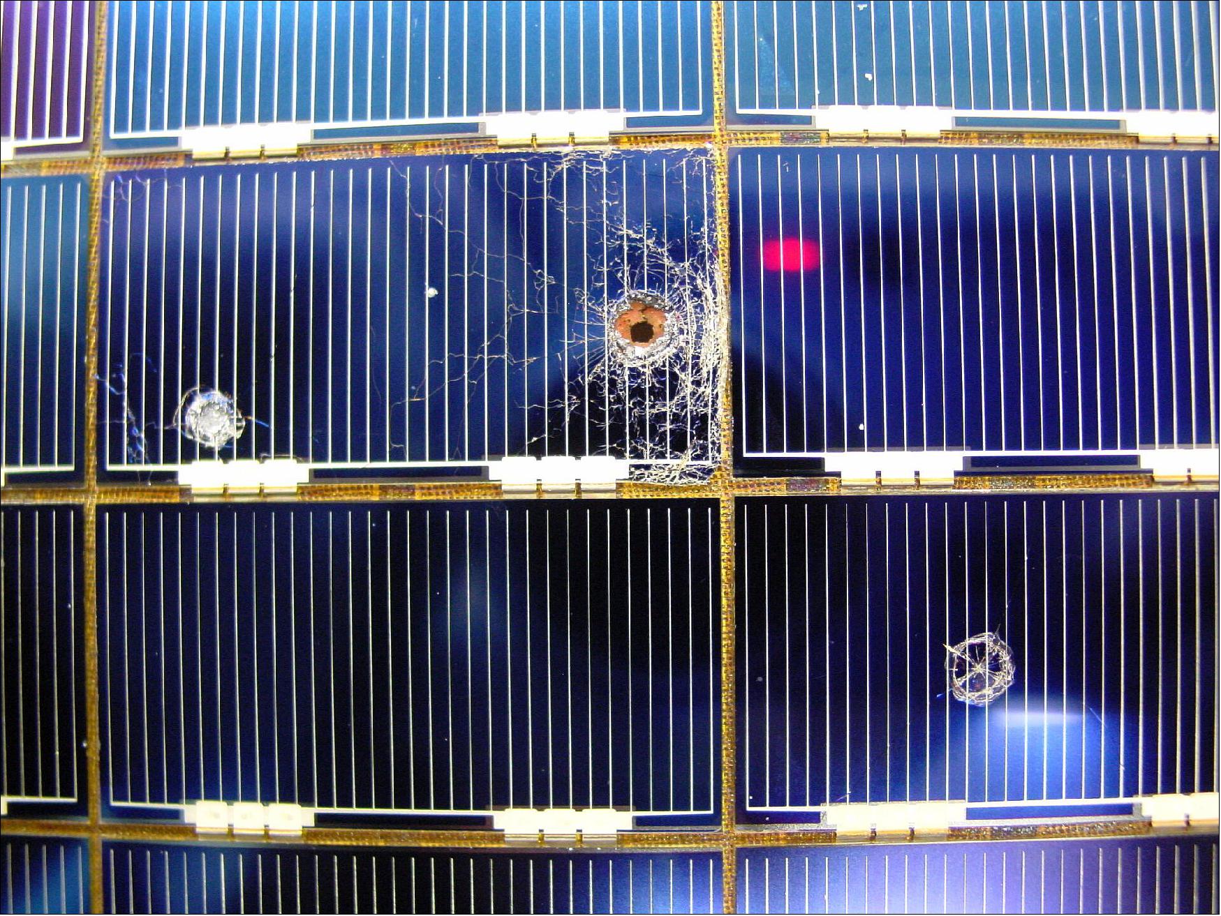 Figure 65: ESA built-solar cells retrieved from the Hubble Space Telescope in 2002. Solar cells in space undergo various kinds of degradation over time – meteorite impacts being the single most violent. Note two front impacts and one from the rear side seen on bottom right (image credit: ESA)