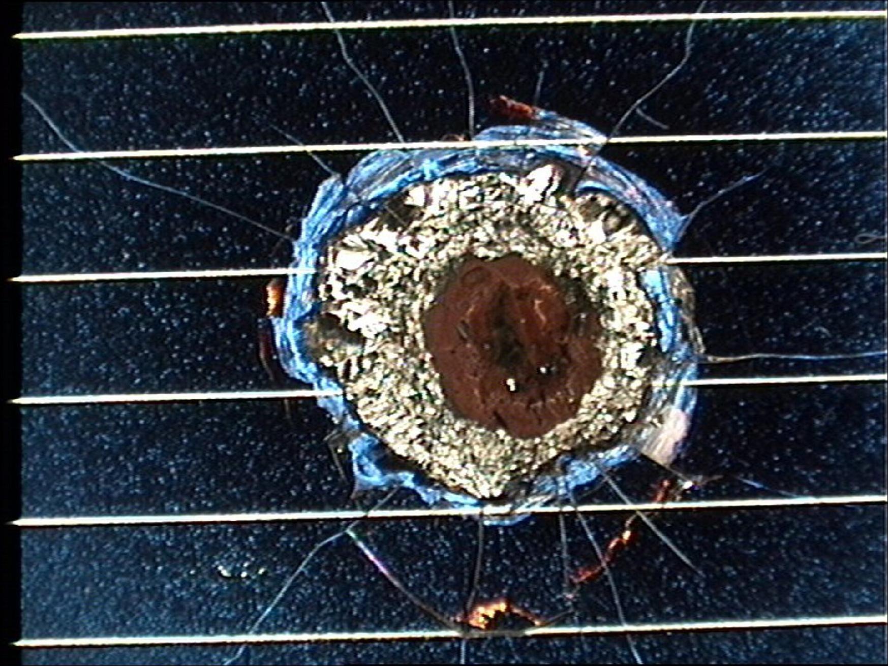 Figure 64: Hubble solar cell impact damage. Post-flight analysis of an impact crater on one of the solar wings deployed by the Space Shuttle Endeavour in 1993 and retrieved by Space Shuttle Columbia in 2002 (image credit: ESA)