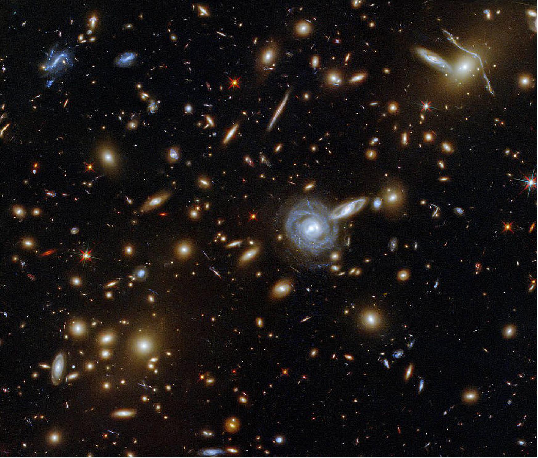 Figure 85: This packed ESA/Hubble Picture of the Week showcases the galaxy cluster ACO S 295, as well as a jostling crowd of background galaxies and foreground stars. Galaxies of all shapes and sizes populate this image, ranging from stately spirals to fuzzy ellipticals. As well as a range of sizes, this galactic menagerie boasts a range of orientations, with spiral galaxies such as the one at the centre of this image appearing almost face on, and some edge-on spiral galaxies visible only as thin slivers of light (image credit: ESA/Hubble & NASA, F. Pacaud, D. Coe; CC BY 4.0)