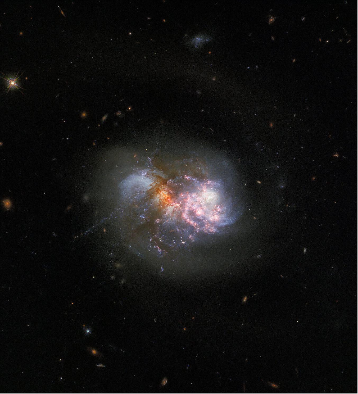Figure 74: This interacting pair of galaxies is a familiar sight; Hubble captured IC 1623 in 2008 using two filters at optical and infrared wavelengths using the Advanced Camera for Surveys. This new image incorporates new data from the Wide Field Camera 3, and combines observations taken in eight filters spanning infrared to ultraviolet wavelengths to reveal the finer details of IC 1623. Future observations of the galaxy pair with the NASA/ESA/CASA James Webb Space Telescope will shed more light on the processes powering extreme star formation in environments such as IC 1623 (image credit: ESA/Hubble & NASA, R. Chandar; CC BY 4.0)