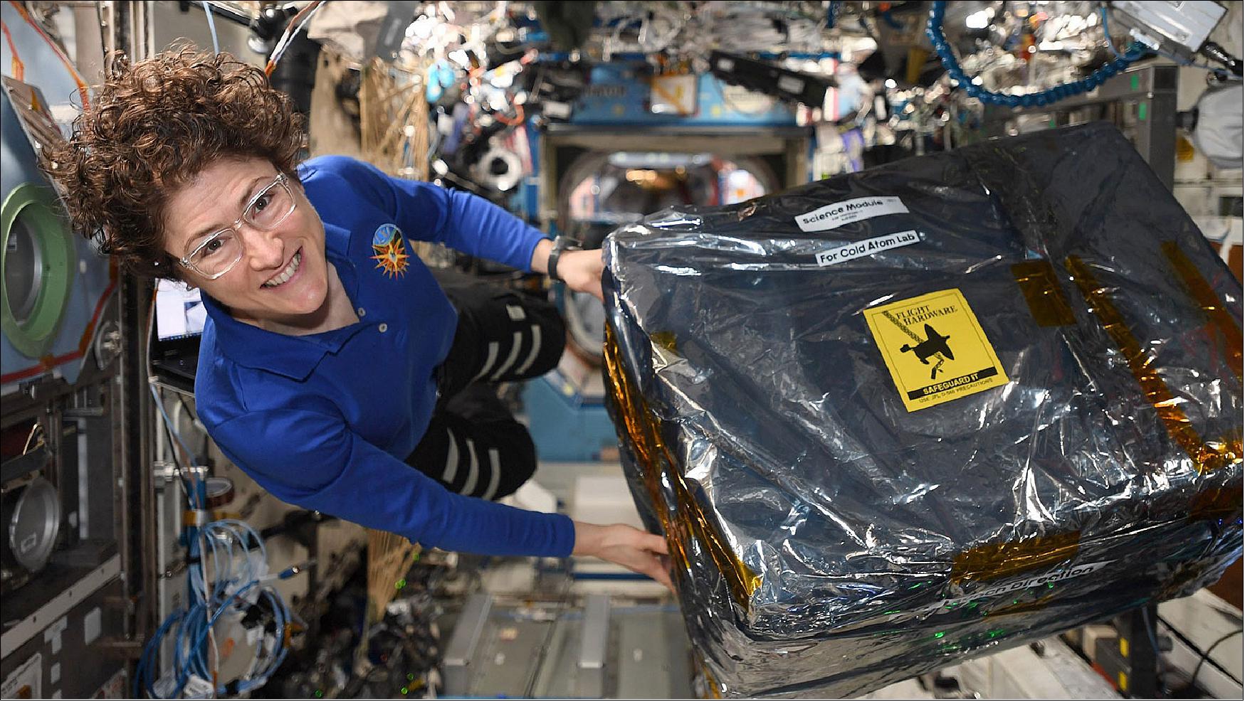 Figure 24: Astronaut Christina Koch unloads new hardware for the Cold Atom Lab aboard the International Space Station the week of Dec. 9, 2020(image credit: NASA)