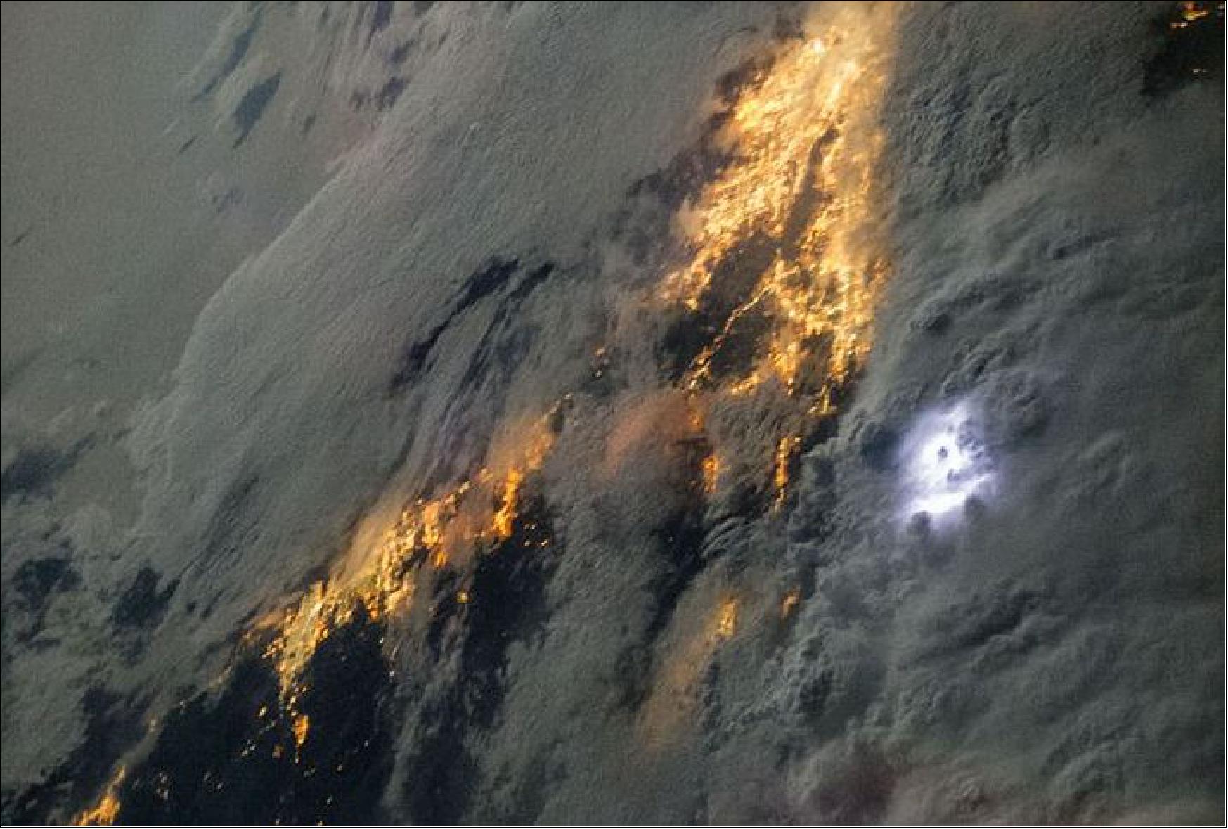 Figure 4: This ISS (International Space Station) crew Earth image of storm clouds over California shows lightning as a white glow to the right of center. The yellow lit areas beneath the clouds are the night lights from the highly populated areas of Los Angeles and San Diego (image credit: NASA,ISS036-E-022863, 21 July 2013) 4)