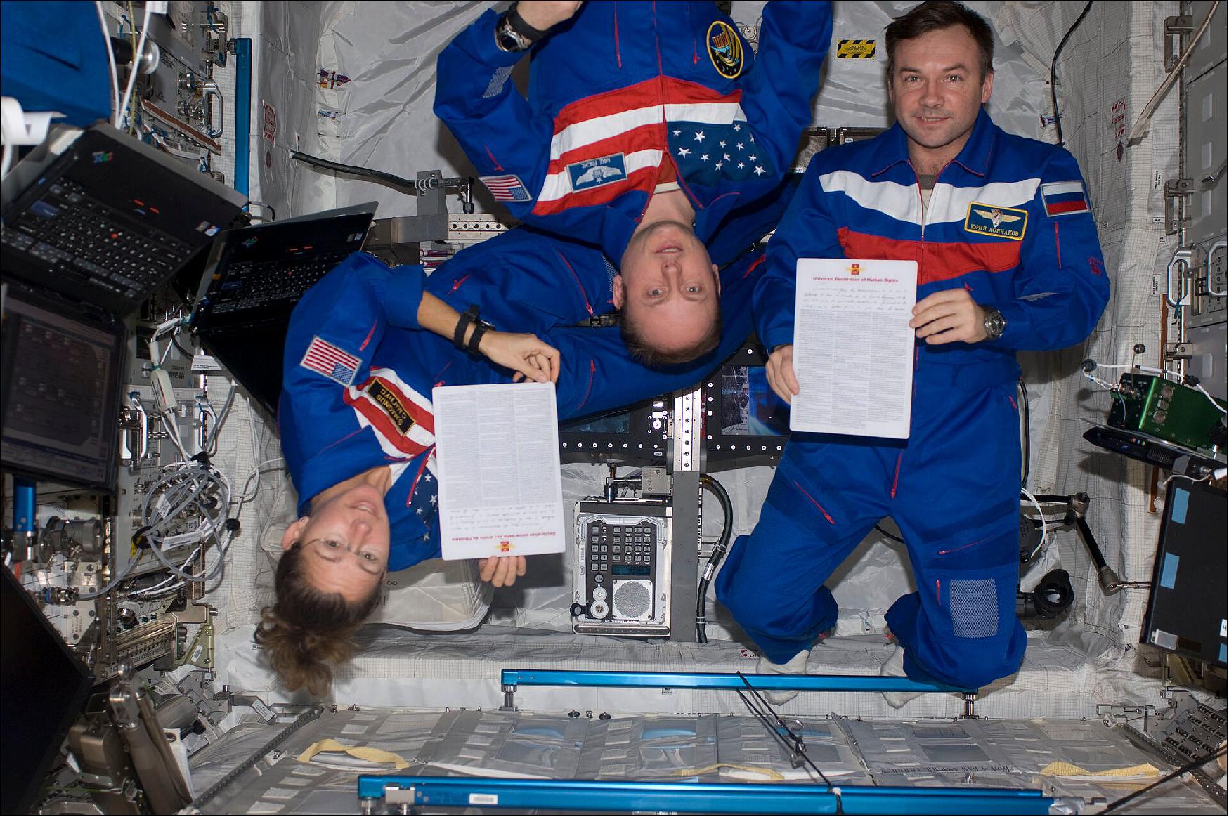 Figure 19: In this image taken in 2008, Expedition 18 crewmembers Sandra Magnus, Mike Fincke and Yury Lonchakov display the Universal Declaration of Human Rights inside the European Columbus laboratory of the International Space Station. This year, as the Station celebrates 20 years of operation, both serve as a reminder of humankind’s ability to come together for a common cause (image credit: NASA)