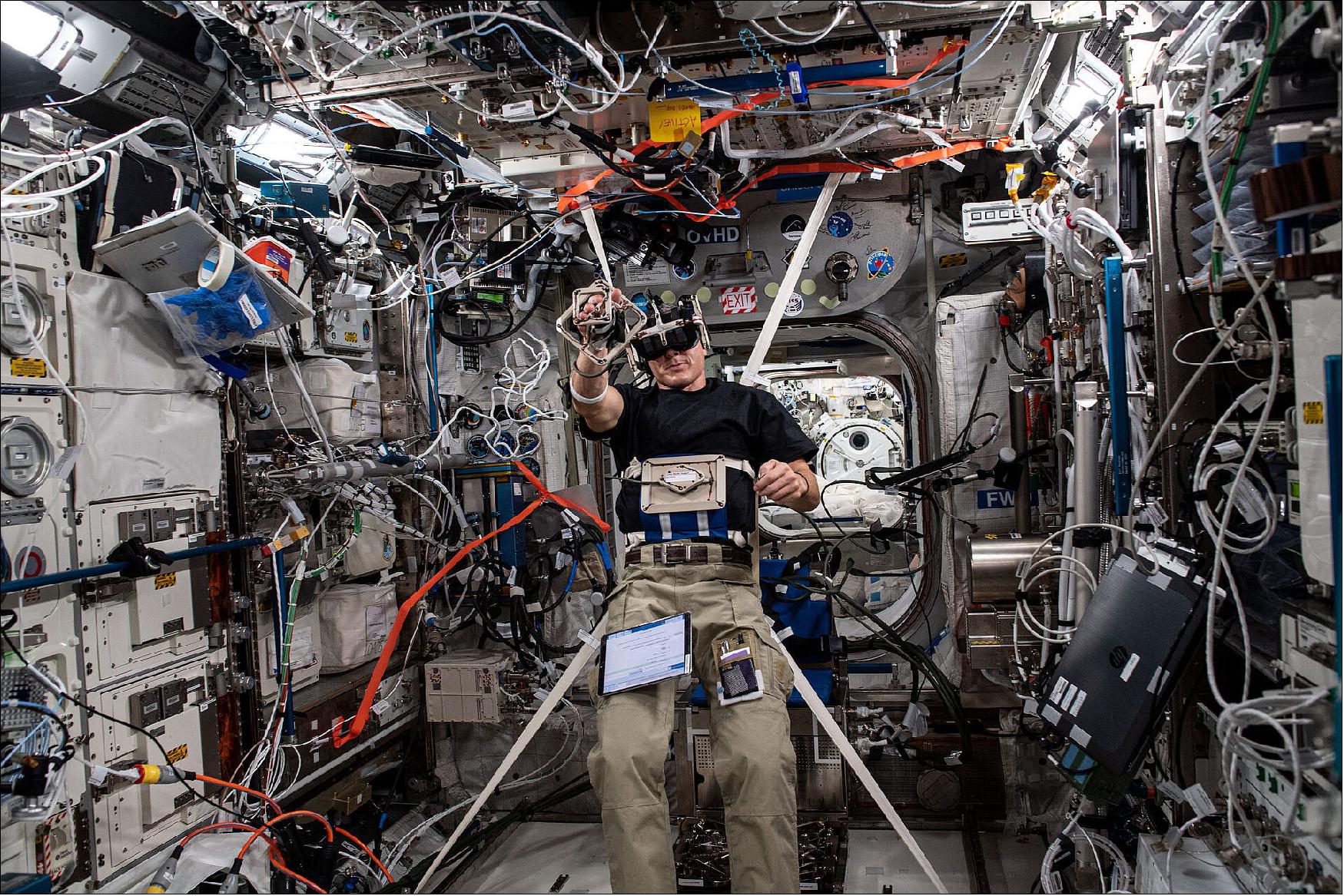 Figure 143: NASA astronaut Mike Hopkins performs the Grasp experiment in the Columbus module of the ISS ahead of the New Year (image credit: ESA/NASA)