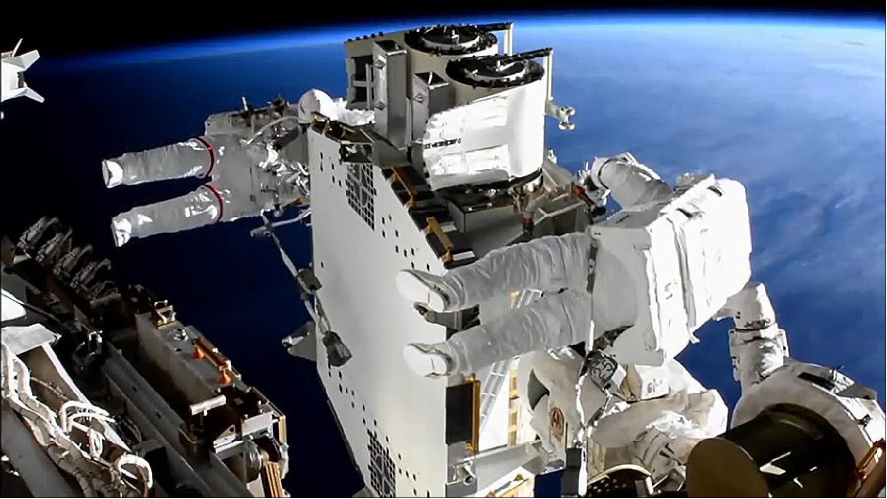 Figure 63: Spacewalkers Shane Kimbrough (foreground) and Thomas Pesquet work to prepare the second roll out solar array ready for installation an upcoming spacewalk (image credit: NASA TV)