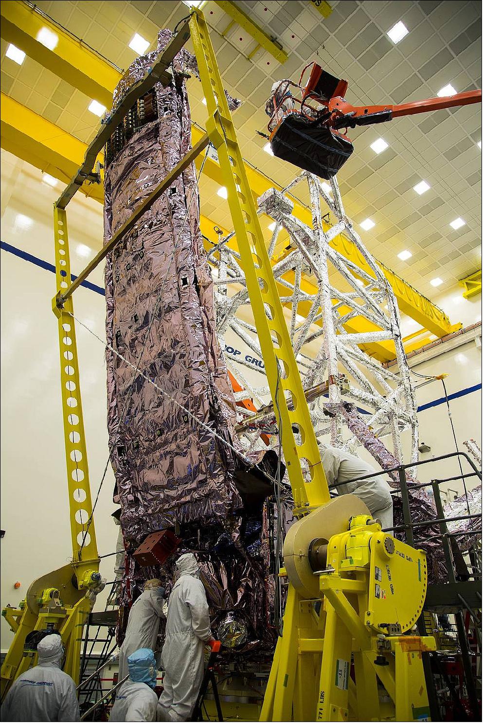 Figure 43: In this photo, technicians delicately inspect stowed sunshield membranes of NASA's JWST on the forward side of the spacecraft. Acoustic testing exposes the spacecraft to similar forces and stress experienced during liftoff, allowing engineers to better prepare it for the rigors of spaceflight (image credit: Northrop Grumman)