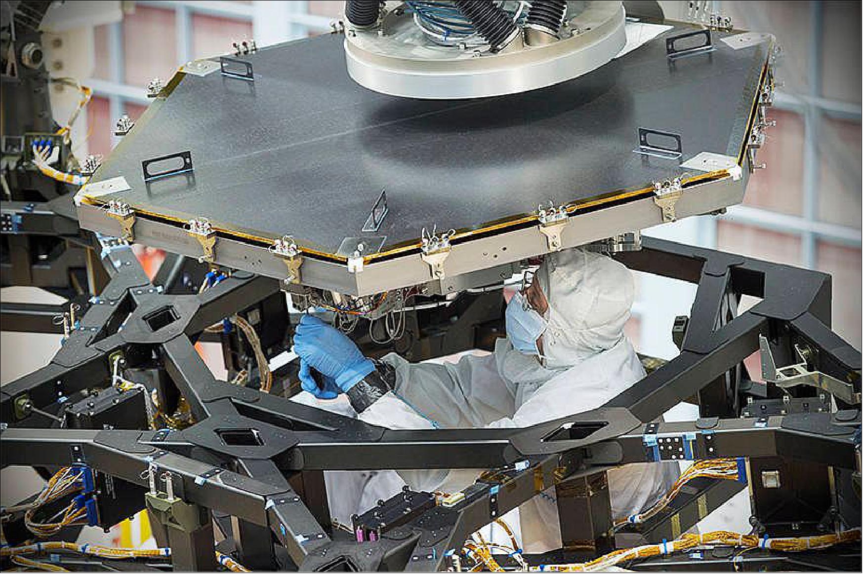 Figure 62: An engineer at NAS/GSFC worked to install the first flight mirror onto the telescope structure (image credit: NASA, Chris Gunn)