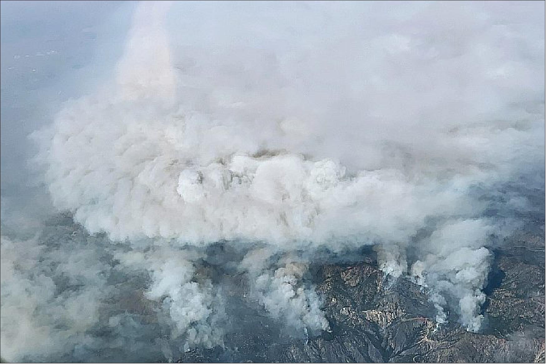Figure 31: While Landsat and other satellites constantly collect data from space that is useful for monitoring fires, NASA sometimes deploys aircraft for advanced fire management research. In this case, the high-flying ER-2 surveyed the Bobcat fire on September 17, 2020, from a height of 65,000 feet (20,000 meters), about twice as high as commercial airliners fly. The pilot of the aircraft took the photograph of smoke rising from the fire shown above. Meanwhile, the Airborne Visible/Infrared Imaging Spectrometer (AVIRIS) sensor on board observed fine details of the fire’s temperature, the water content of vegetation canopies, characteristics of the smoke, and burn severity (image credit: NASA Earth observatory)