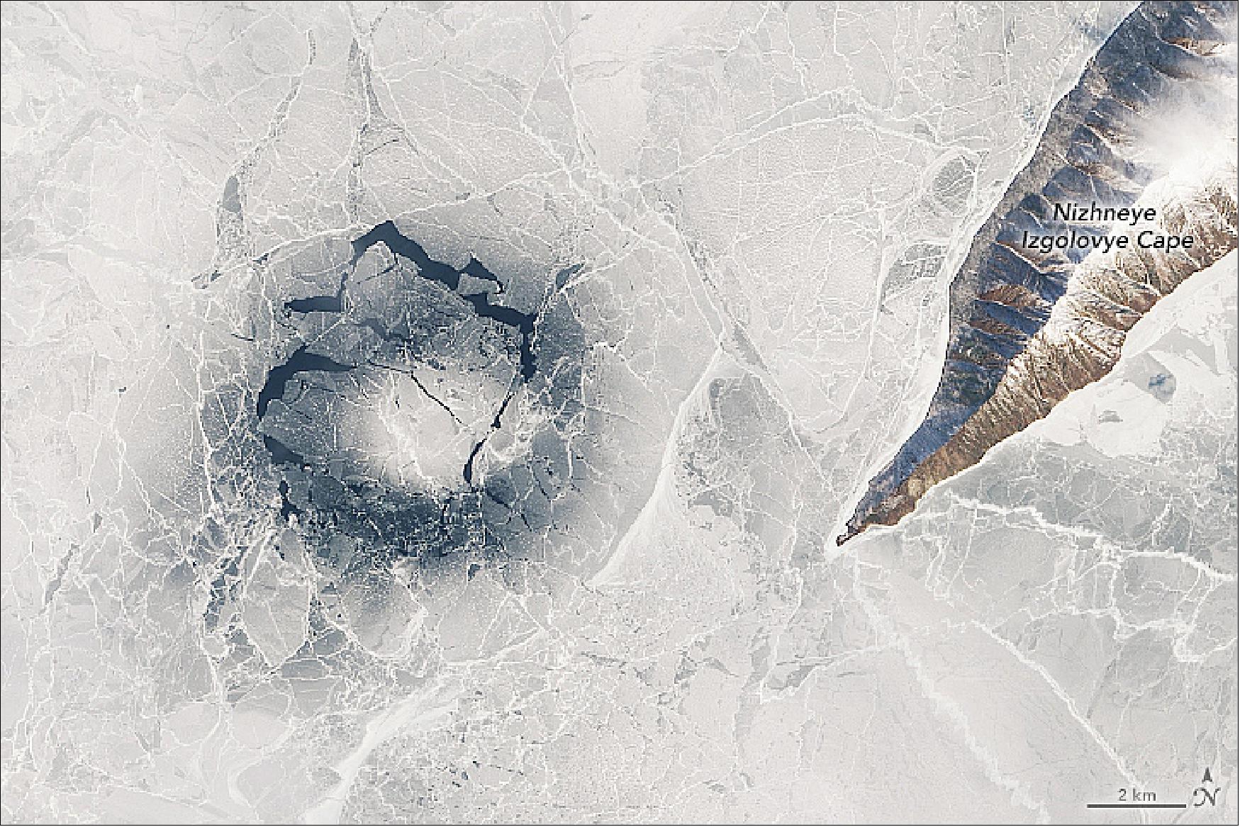 Figure 127: The puzzling features are most easily seen from above, but they pose real risks at the surface. The Landsat-8 image shows an ice ring in the central part of the lake on April 1, 2016. That ring was particularly well-studied because Kouraev and colleagues were nearby, taking measurements of the ice and underlying water. The thin ice of the ring appears darker and more transparent than the whiter, thicker ice surrounding it (image credit: NASA Earth Observatory, image by Lauren Dauphin, using Landsat data from the U.S. Geological Survey. Story by Adam Voiland)