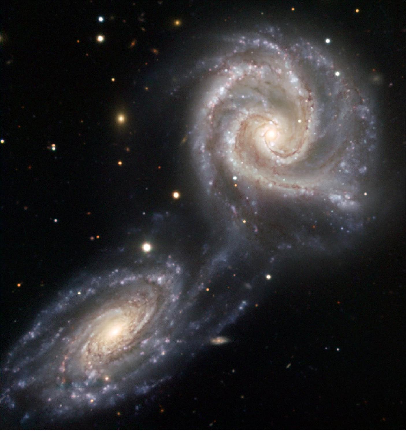 Figure 17: NGC 5426 and NGC 5427 are two spiral galaxies of similar sizes engaged in a dramatic dance. It is not certain that this interaction will end in a collision and ultimately a merging of the two galaxies, although the galaxies have already been affected. Together known as Arp 271, this dance will last for tens of millions of years, creating new stars as a result of the mutual gravitational attraction between the galaxies, a pull seen in the bridge of stars already connecting the two. Located 90 million light-years away towards the constellation of Virgo (the Virgin), the Arp 271 pair is about 130 000 light-years across. It was originally discovered in 1785 by William Herschel. Quite possibly, our own Milky Way will undergo a similar collision in about five billion years with the neighboring Andromeda galaxy, which is now located about 2.6 million light-years away from the Milky Way (image credit: ESO)