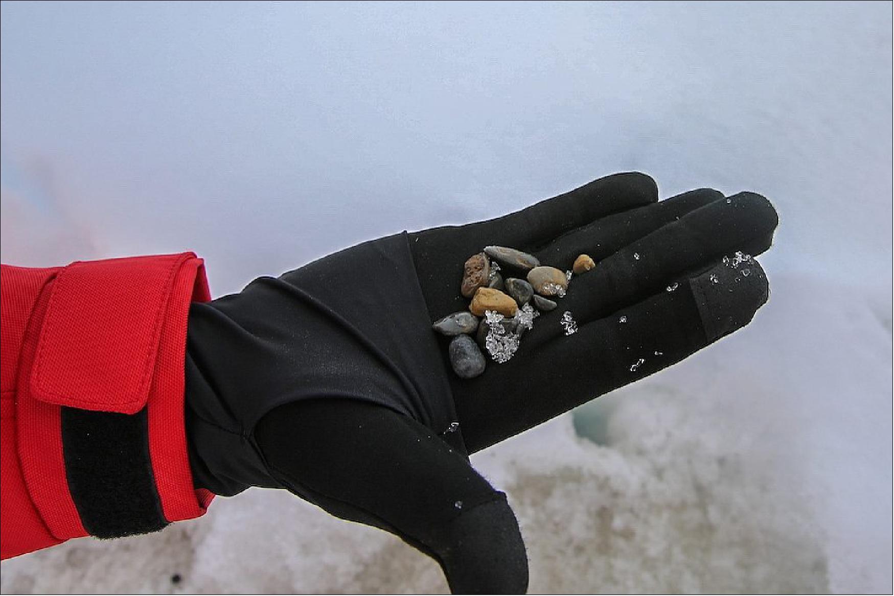 Figure 23: IRD (Ice Rafted Debris) in Sea ice found on the MOSAiC Floe Fortress during Leg 4. Brownish patterns on ice show the abundance of the gravels (Photo: Lisa Grosfeld)