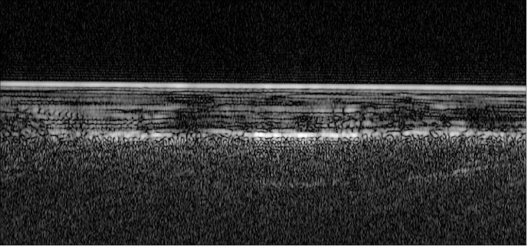 Figure 74: ESA's Mars Express has used radar signals bounced through underground layers of ice to identify a pond of water buried below the surface. This image shows an example radar profile for one of 29 orbits over the 200 x 200 km study region in the south polar region of Mars. The bright horizontal feature at the top corresponds to the icy surface of Mars. Layers of the south polar layered deposits – layers of ice and dust – are seen to a depth of about 1.5 km. Below is a base layer that in some areas is even much brighter than the surface reflections, while in other places is rather diffuse. The brightest reflections from the base layer – close to the center of this image – are centered around 193º/81ºS in all intersecting orbits, outlining a well-defined, 20 km wide subsurface anomaly that is interpreted as a pond of liquid water (image credit:ESA/NASA/JPL/ASI/University of Rome)