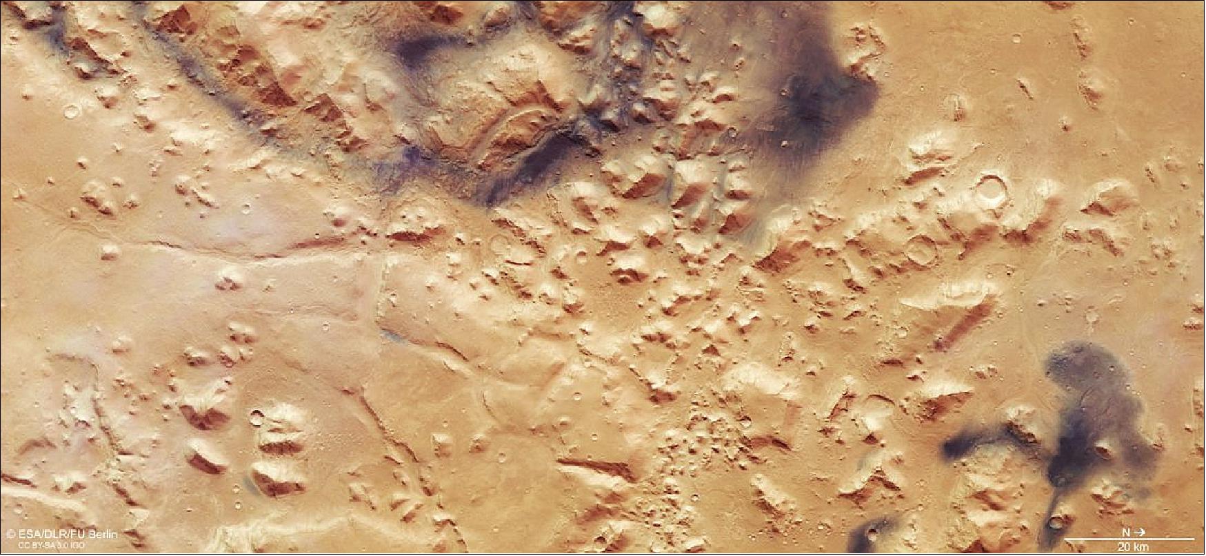 Figure 66: This color view shows the landscape around Nili Fossae, an escarpment sitting between the northern lowlands and southern highlands of Mars. It was created using data from the nadir channel of the HRSC on ESA’s Mars Express orbiter, the field of view which is aligned perpendicular to the surface of Mars, and the camera’s color channels. The data were acquired during spacecraft orbit 17916. The ground resolution is about 18 m/pixel and the images cover a part of the martian surface centered on 78ºE, 28ºN. North is to the right. (image credit: ESA/DLR/FU Berlin, CC BY-SA 3.0 IGO)