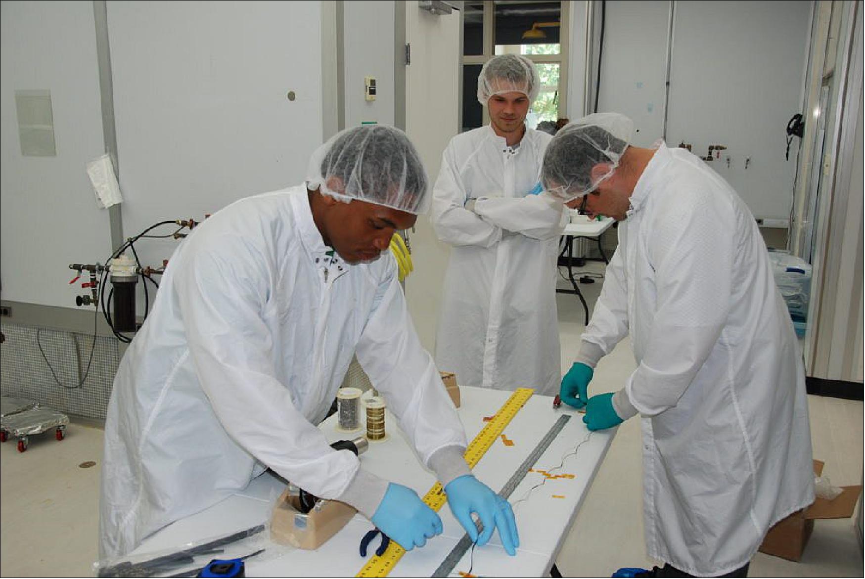 Figure 16: Students Demetrius Tuggle, David Conran, and Joe Smolsky assemble a wiring harness for the NEID ECS (image credit: PSU)