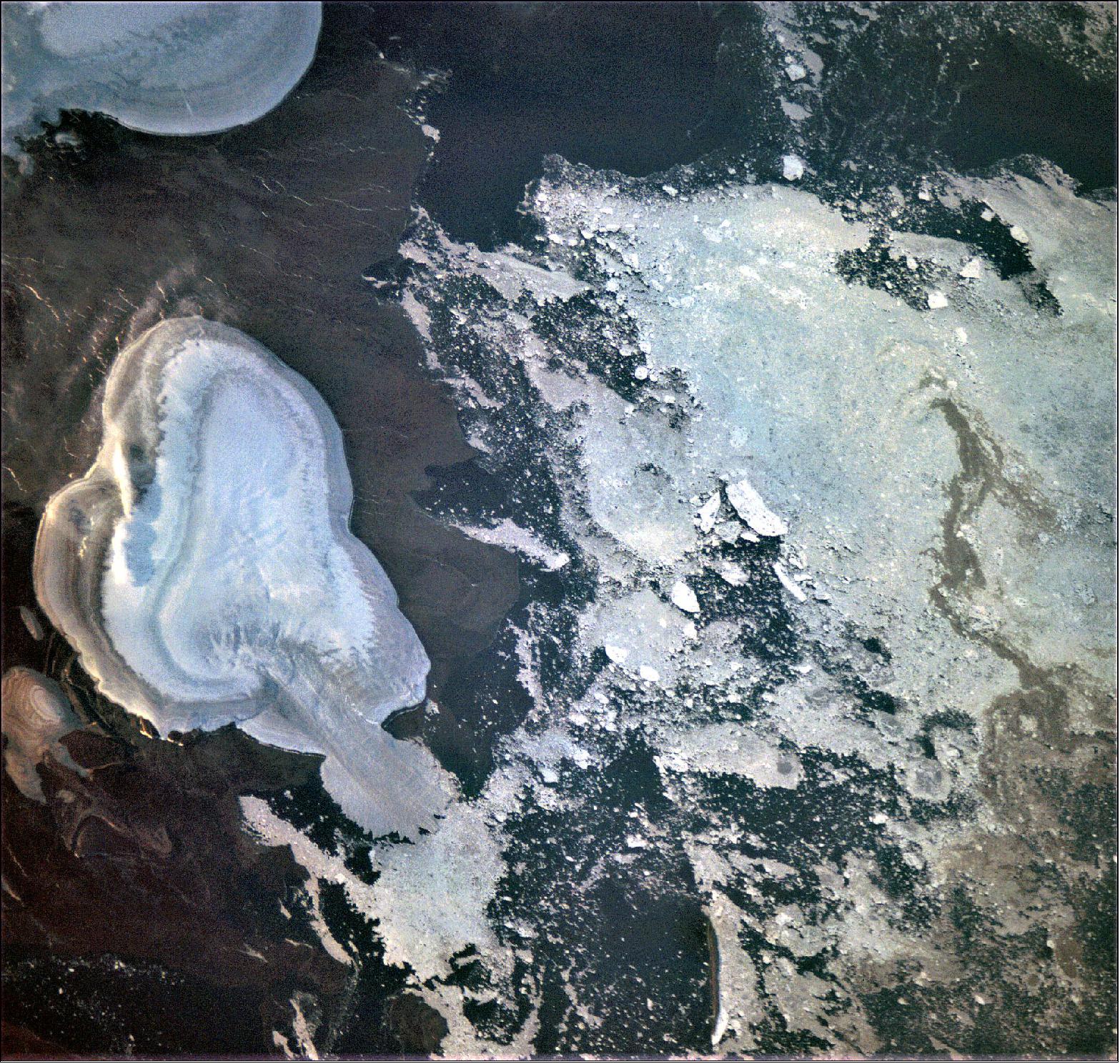 Figure 39: This image reveals part of an impressive uninhabited island north of Russia, first discovered in 1913. October Revolution Island is now known to be the 59th largest island in the world, and houses five domed ice caps – a mass of ice that covers less than 50,000 km2 (whereas larger ice masses are known as ice sheets). Taken on 14 August 2020 by ESA’s OPS-SAT spacecraft during commissioning of its high-definition camera, the left half of the image shows the island with its characteristic icefields and tundra, and right part of the image shows the Arctic Laptev Sea with large amounts of drift ice (image credit: ESA) 44)