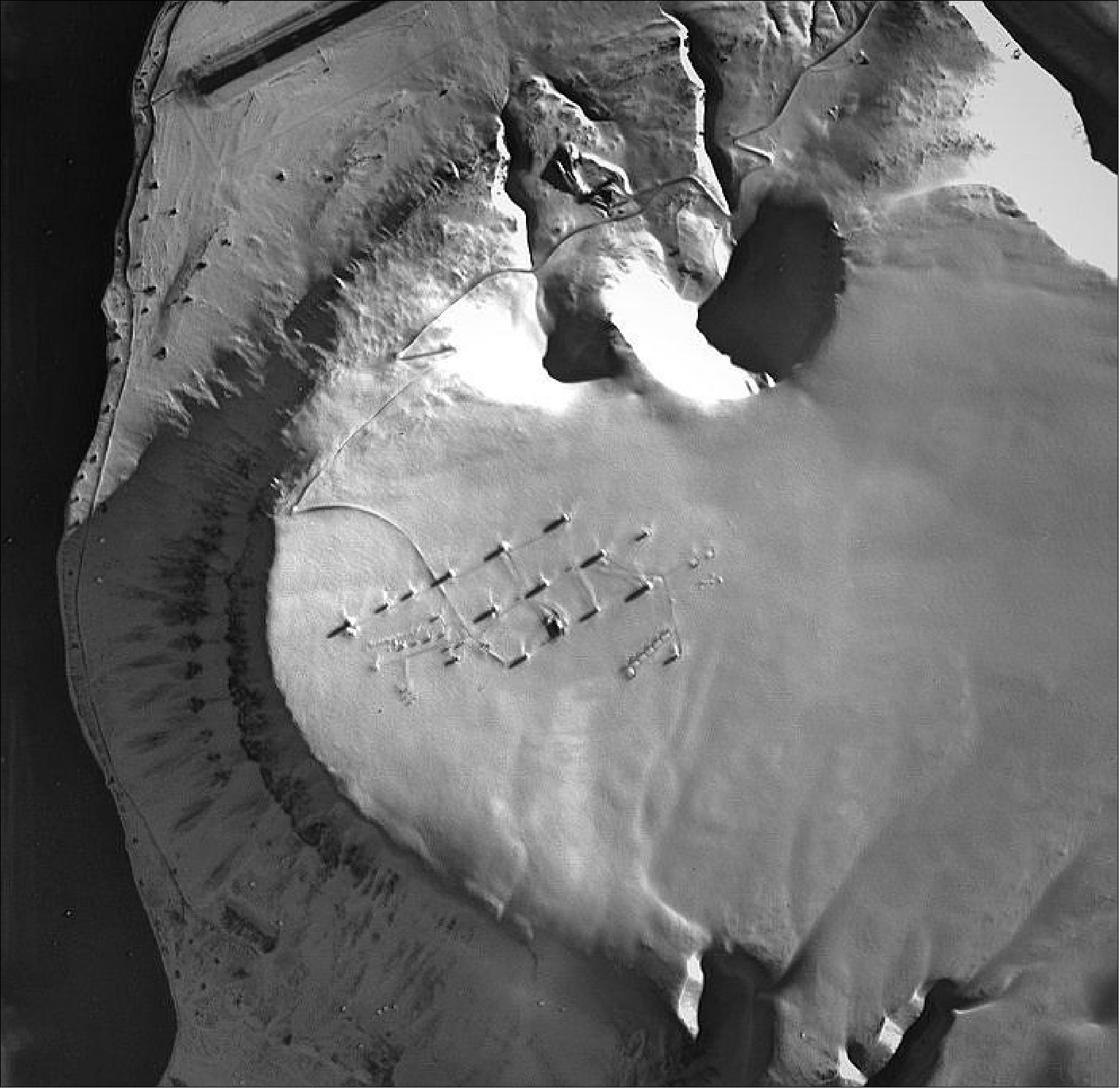 Figure 16: This HRC image of PROBA-1 was acquired on April 16, 2016. Long shadows cast across the snow give a frosty view of the covered domes of Europe’s most northerly ground station, as seen by the smallest camera on ESA’s veteran PROBA-1 minisatellite. Note the slice of airstrip, cleared of snow, on the left side at the very top of the image (image credit: ESA)