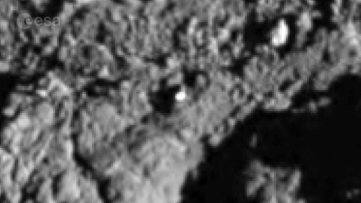 Figure 40: A light shining in the darkness. Rosetta's Philae lander touched down on Comet 67P/Churyumov-Gerasimenko on 12 November 2014 and made multiple contacts with the surface before arriving at its final resting place. This animated gif focuses on the second touchdown site, which is characterized by a bright patch of exposed water-ice covering an area of about 3.5 m2. Although the ice was mostly in shadow at the time of the landing, the Sun was directly illuminating the area when these images were taken 22 months later, lighting it up like a beacon to stand out against everything around it. In this animated gif, every second image has its brightness/contrast fully reduced to show how the ice in the crevice is brighter than all of the surrounding regions [image credit: ESA/Rosetta/Philae/ROLIS/DLR; all other images: ESA/Rosetta/MPS for OSIRIS Team MPS/UPD/LAM/IAA/SSO/INTA/UPM/DASP/IDA; Analysis: O'Rourke et al (2020)]