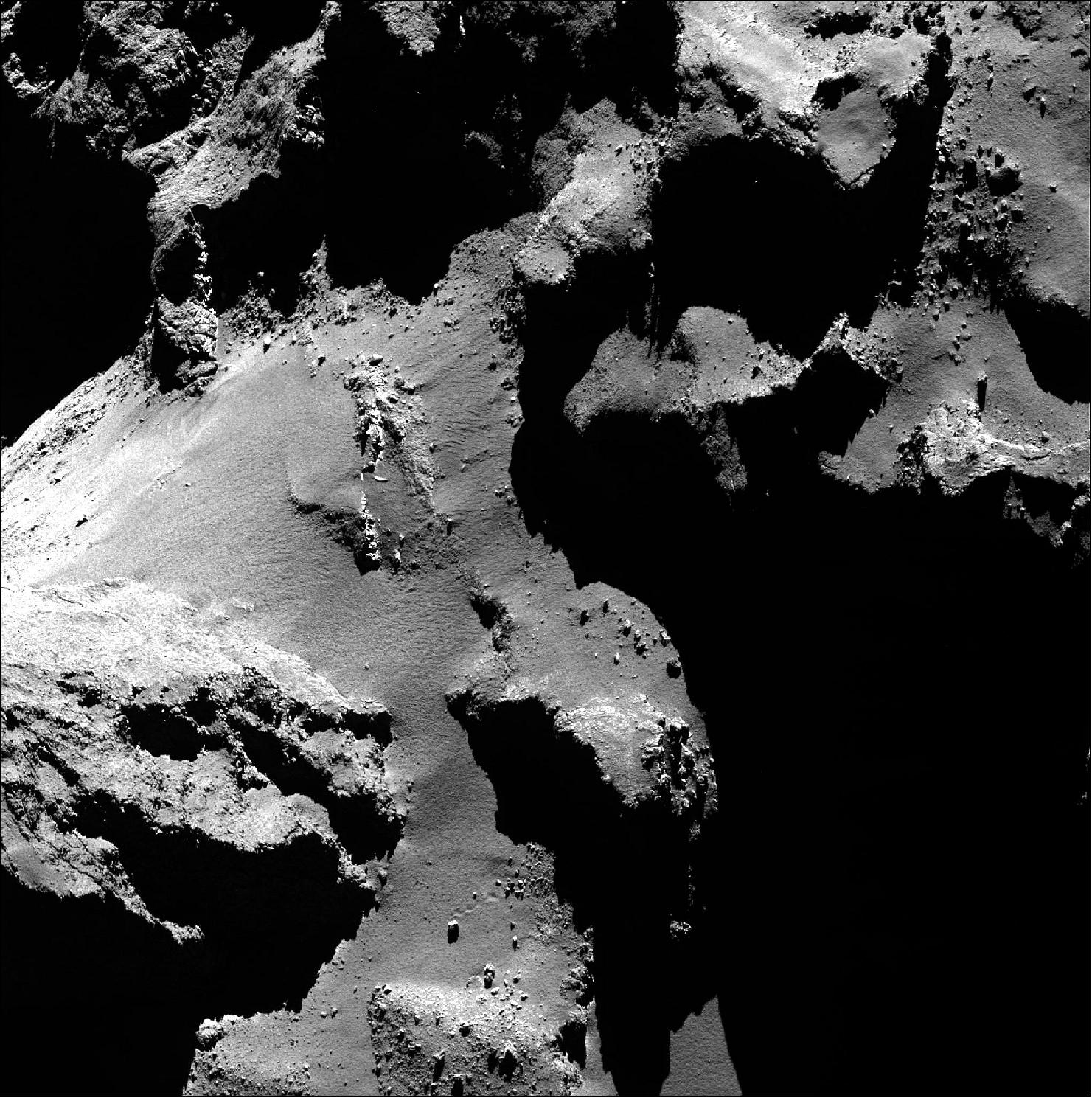 Figure 52: Bouncing boulder on Comet 67P/C-G. An example of a boulder having moved across the surface of Comet 67P/Churyumov-Gerasimenko's surface, captured in Rosetta's OSIRIS imagery. The image was taken with the narrow-angle camera and shows the boulder in the lower third of the image [image credit: ESA/Rosetta/MPS for OSIRIS Team MPS/UPD/LAM/IAA/SSO/INTA/UPM/DASP/IDA (CC BY-SA 4.0)]