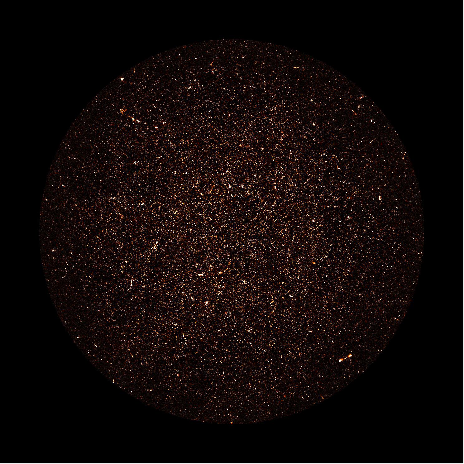 Figure 75: MeerKAT image of radio galaxies: Thousands of galaxies are visible in this radio image covering a square degree of sky near the south celestial pole, made by the MeerKAT radio telescope array in South Africa. The brightest spots are luminous radio galaxies powered by supermassive black holes. The myriad faint dots are distant galaxies like our own Milky Way, too faint to have been detected before now, which reveal the star-formation history of the universe. Most galaxies are visible in the central part of the image, where the telescope is most sensitive (image credit: SARAO; NRAO/AUI/NSF)
