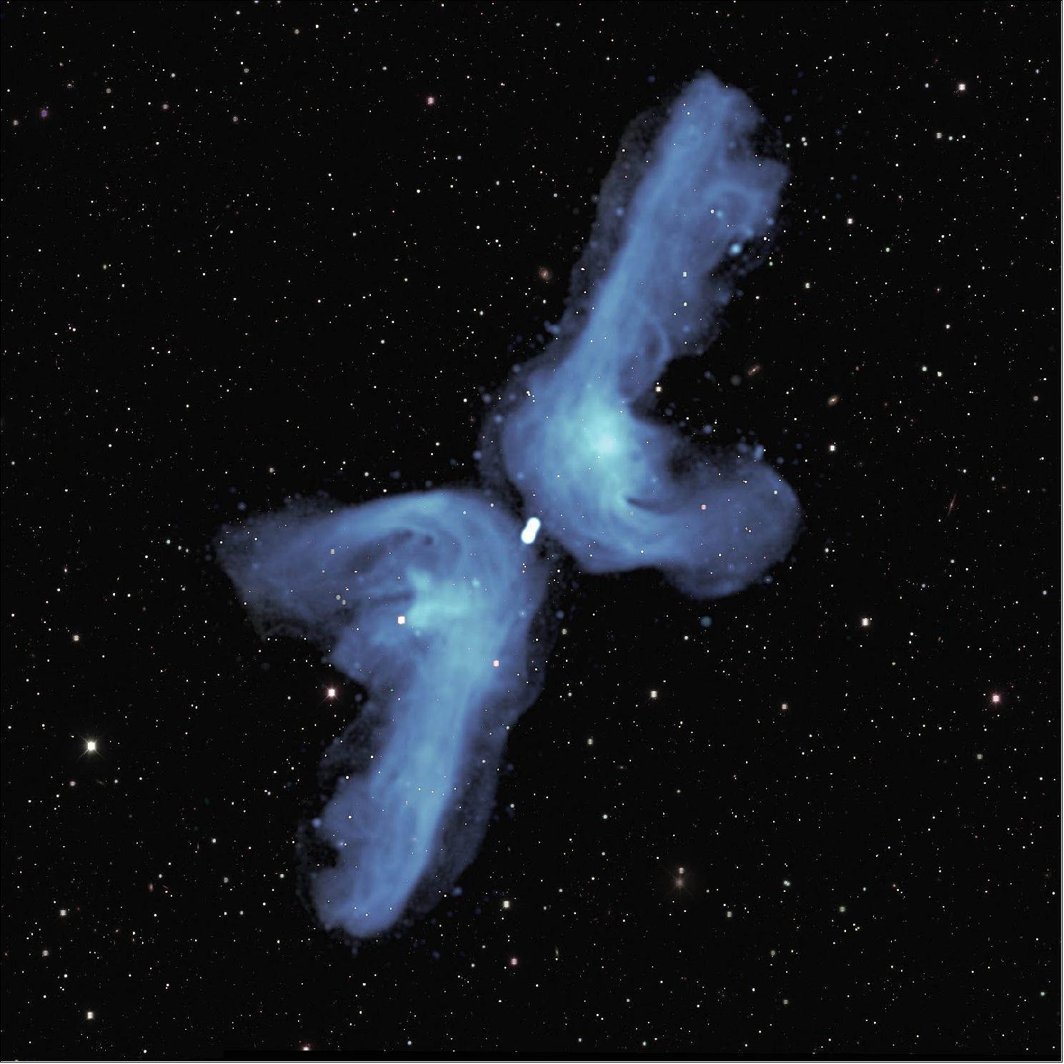 Figure 72: The galaxy PKS 2014-55, located 800 million light years from Earth, is classified as ‘X-shaped’ because of its appearance in previous relatively blurry images. The detail provided in this radio image obtained with the MeerKAT telescope indicates that its shape is best described as a ‘double boomerang’. Two powerful jets of radio waves, indicated in blue color, each extend 2.5 million light years into space (comparable to the distance between the Milky Way and the Andromeda galaxy, our nearest major neighbor). Eventually, they are ‘turned back’ by the pressure of tenuous intergalactic gas. As they flow back towards the central galaxy, they are deflected by its relatively high gas pressure into the shorter, horizontal, arms of the boomerang. The background image shows visible light from myriad galaxies in the distant universe. Adapted from W Cotton et al, MNRAS (2020), image credit: NRAO/AUI/NSF; SARAO; DES