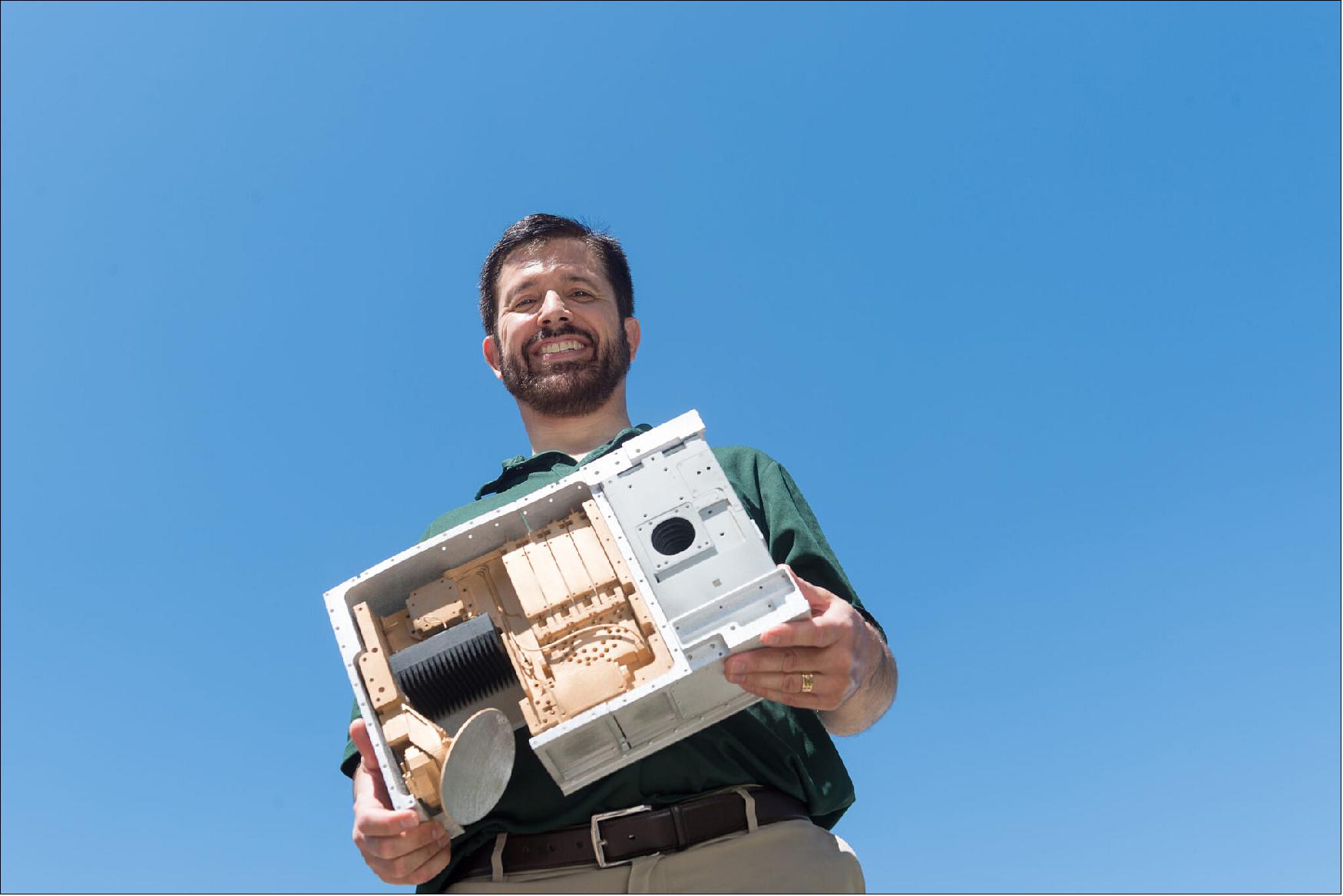 Figure 9: Steven Reising, professor of electrical and computer engineering, holds a model of the TEMPEST-D satellite. After meeting all its benchmarks for demonstrating small-satellite weather forecasting capabilities during its first 90 days, a Colorado State University experimental satellite is operating after more than one year in low-Earth orbit (image credit: Bill Cotton)