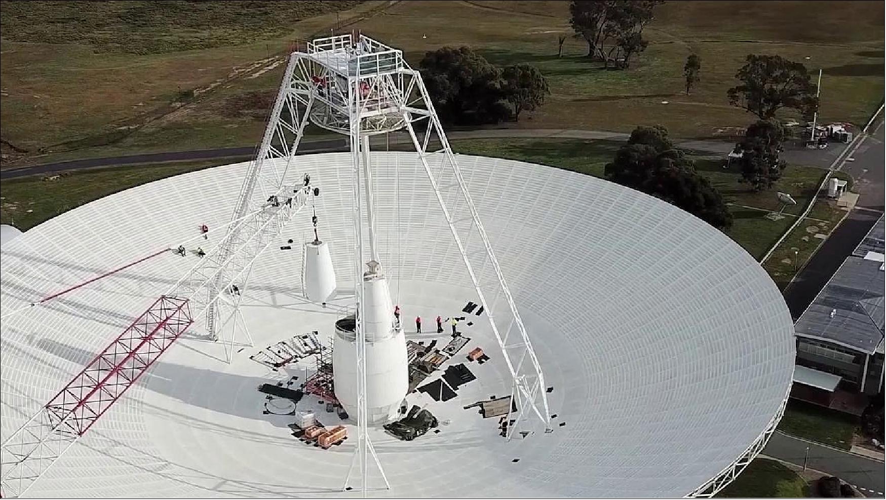 Figure 6: Crews conduct critical upgrades and repairs to the 70-meter-wide (230-foot-wide) radio antenna Deep Space Station 43 in Canberra, Australia. In this image, one of the antenna's white feed cones (which house portions of the antenna receivers) is being moved by a crane (image credit: CSIRO)